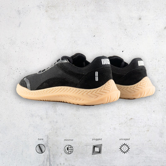 Black barefoot and minimal sneakers with tan soles on a light gray background