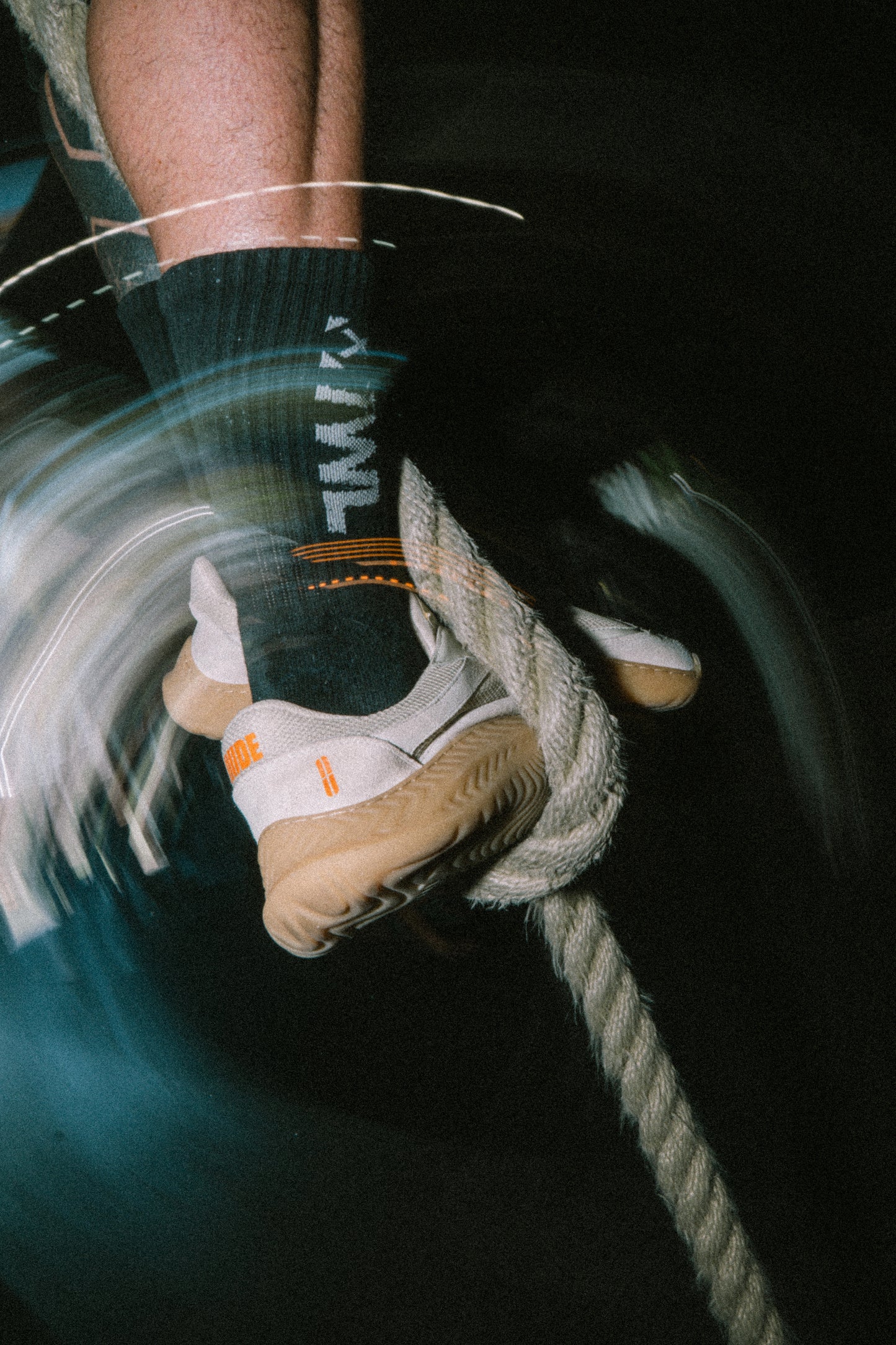 Close-up of a person's foot wearing a sock with text and a barefoot and minimal shoe on a dark background