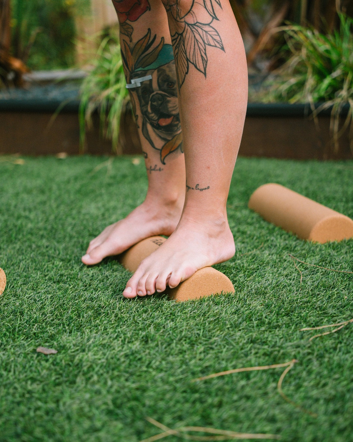 Bare feet standing on The Nude Foot cork foam rollers for post-WOD foot recovery, balance and mobility