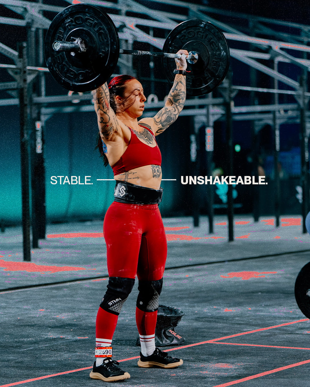 Athlete performing an overhead barbell lift in a CrossFit box wearing The Nude Foot shoes